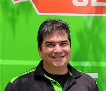 Technician smiling in front of green background