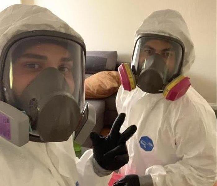 Two employees in hazmat suits.