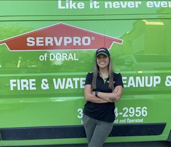 women with arms crossed in front of servpro van